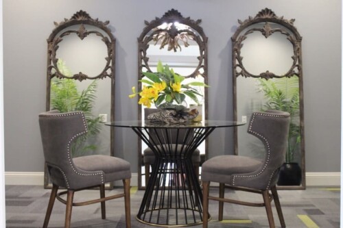 Clubhouse seating area with round table and mirrors at Clairmont at Campostella Station Apartments