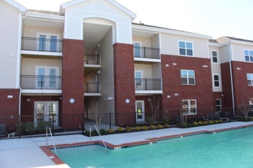 Apartment building with balconies beside the pool at Clairmont at Campostella Station Apartments