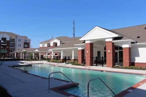 Swimming pool deck and clubhouse at Clairmont at Campostella Station Apartments